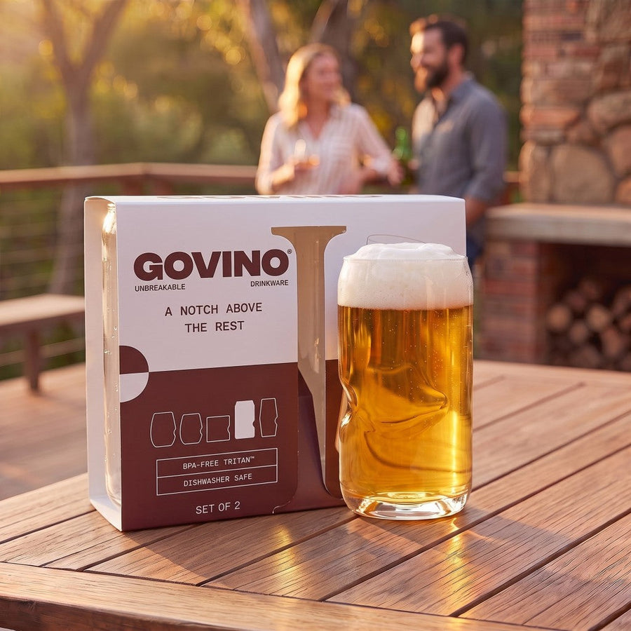 Govino Premium Shatterproof Can gift box beside a frothy beer glass on a wooden deck at golden hour